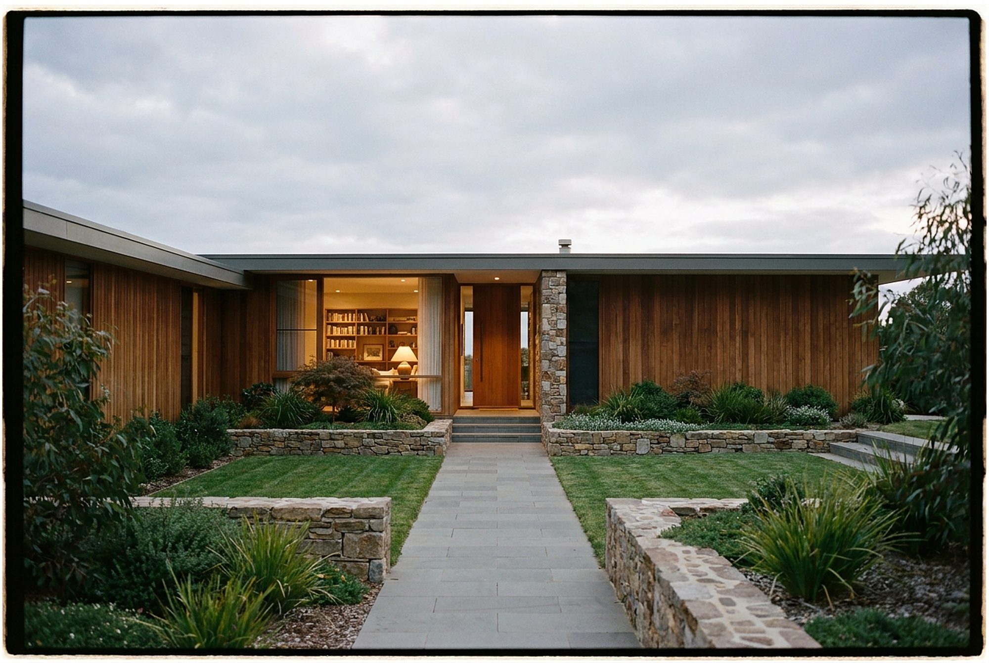 Styled exterior scene: painted-brick transitional home at golden hour with lavender and olive trees